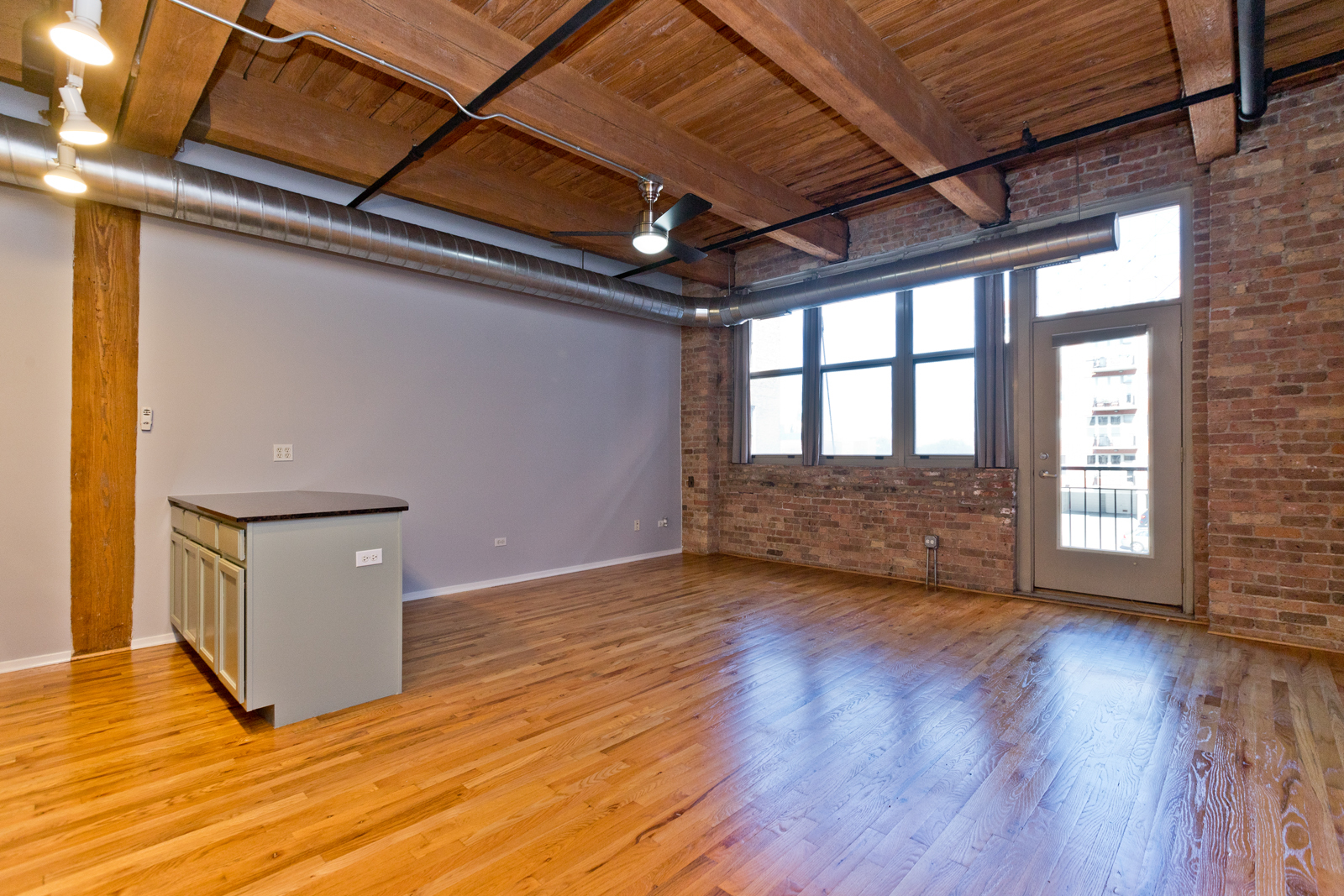 1500 West Monroe Street, Unit 515 Chicago, IL 60607 - Photo 5 of 10 a view of an empty room with wooden floor and a window