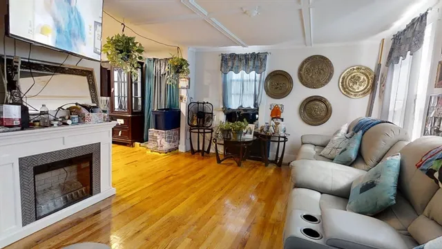 a living room with couches a flat screen tv and kitchen view
