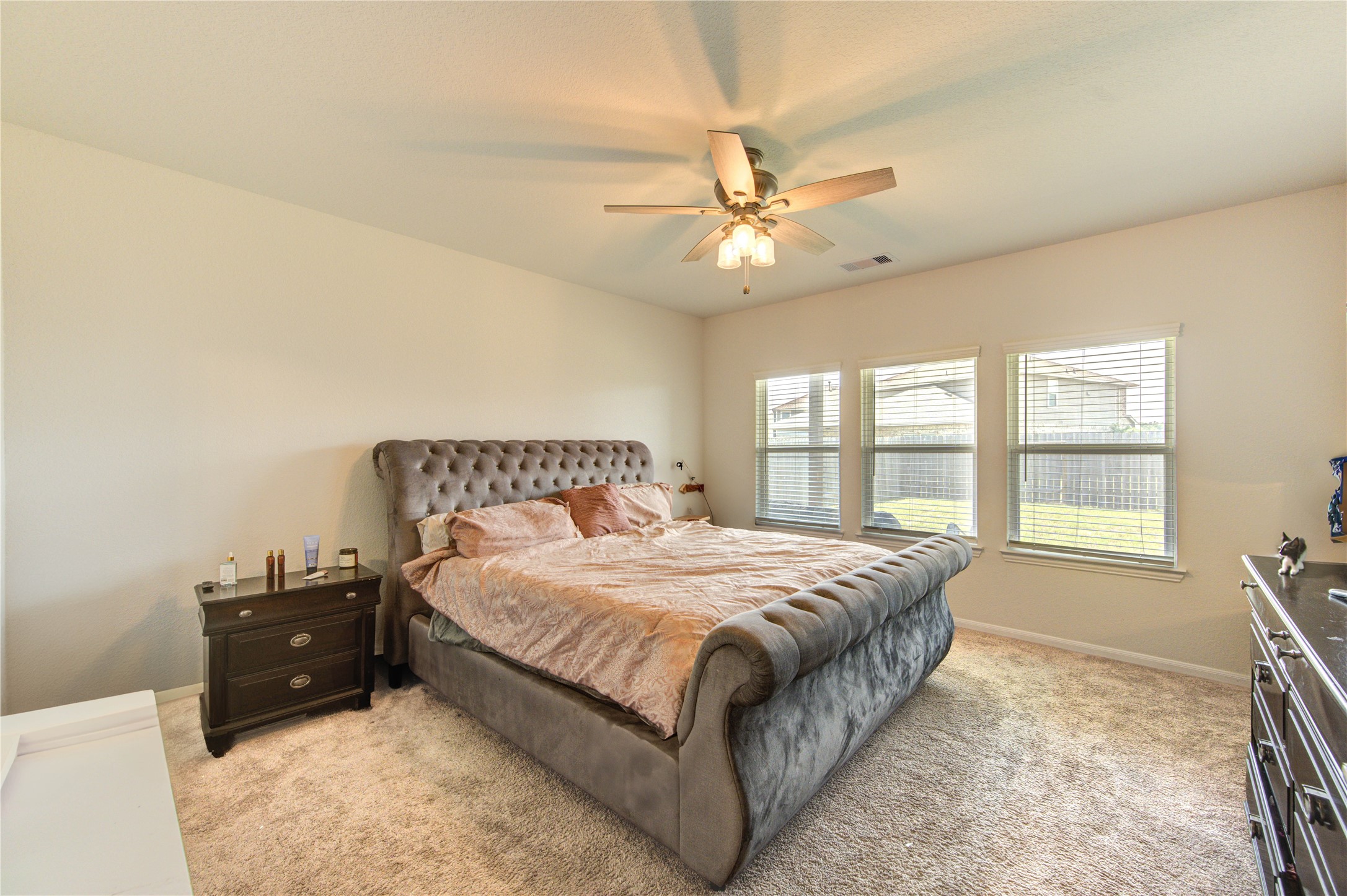 20951 New Proper Drive New Caney, TX 77357 - Photo 20 of 28 a spacious bedroom with a bed and a chandelier