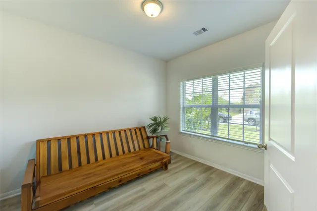 a view of a room with wooden floor and a window