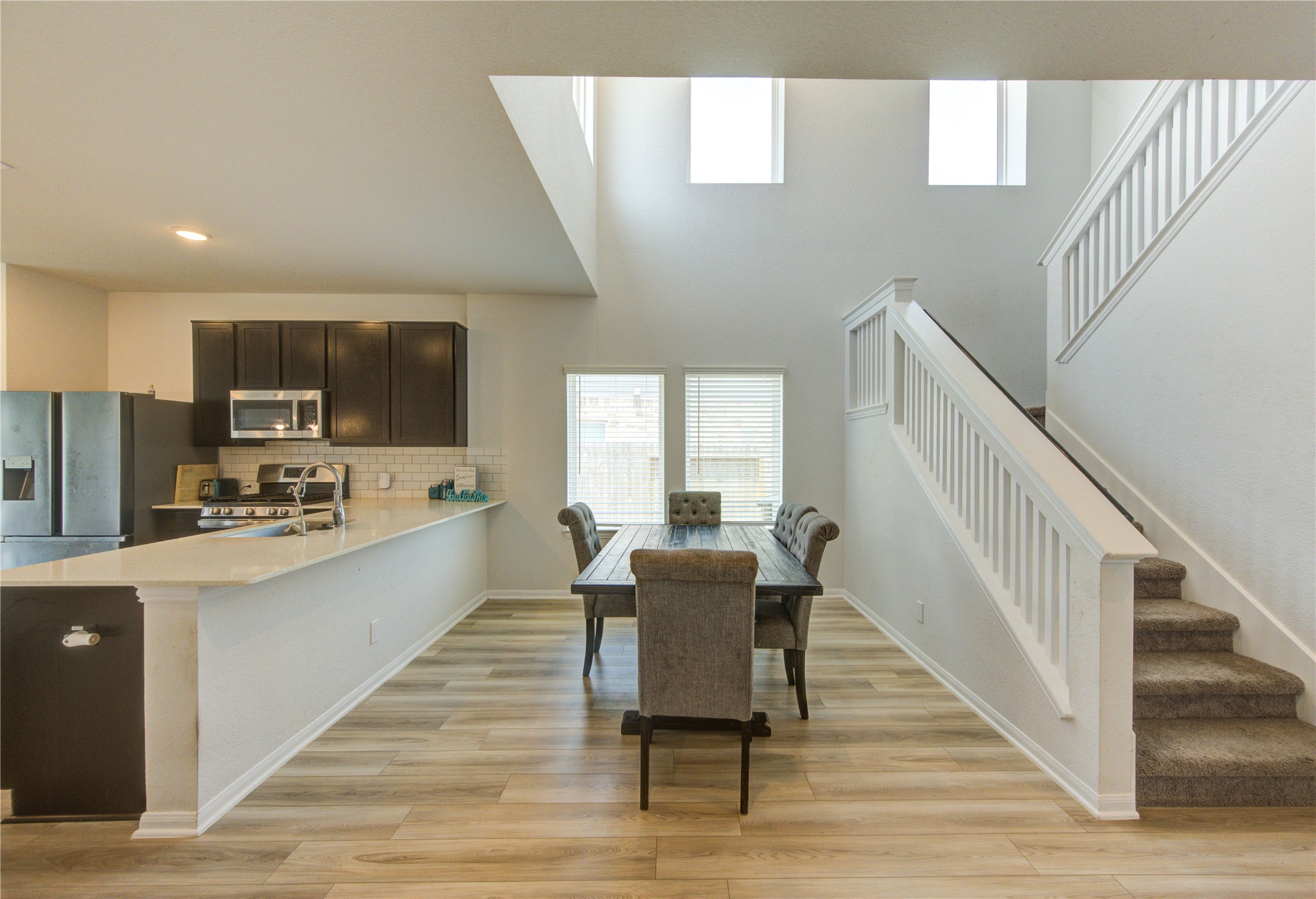 20951 New Proper Drive New Caney, TX 77357 - Photo 4 of 28 a living room with stainless steel appliances furniture a dining table wooden floor and a kitchen view