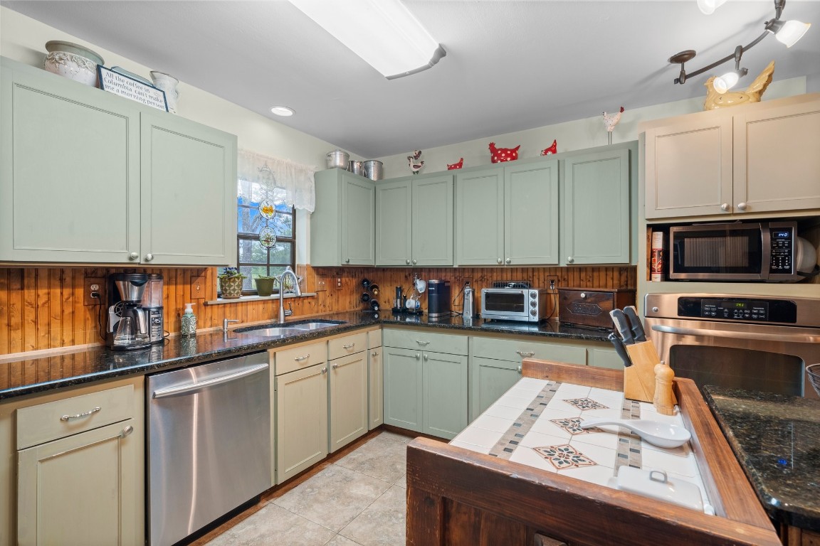 2400 Bowler Road Magnolia, TX 77355 - Photo 15 of 48 a kitchen with stainless steel appliances kitchen island granite countertop a sink stove and cabinets