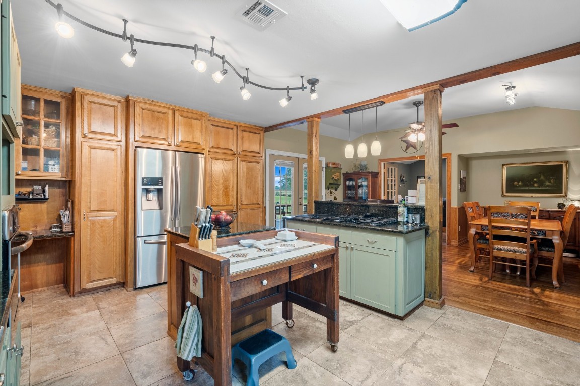 2400 Bowler Road Magnolia, TX 77355 - Photo 16 of 48 a kitchen with stainless steel appliances kitchen island granite countertop a table chairs sink and cabinets