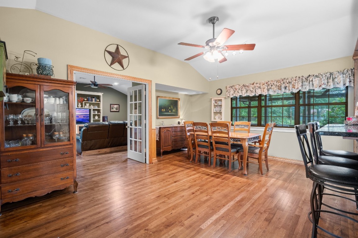 2400 Bowler Road Magnolia, TX 77355 - Photo 17 of 48 a dining room with furniture a chandelier and wooden floor