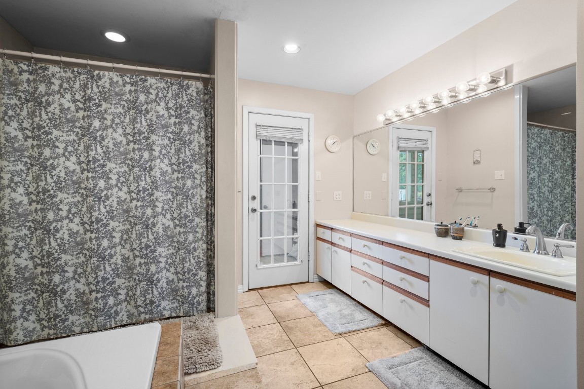 2400 Bowler Road Magnolia, TX 77355 - Photo 29 of 48 a bathroom with a double vanity sink a toilet a mirror and shower