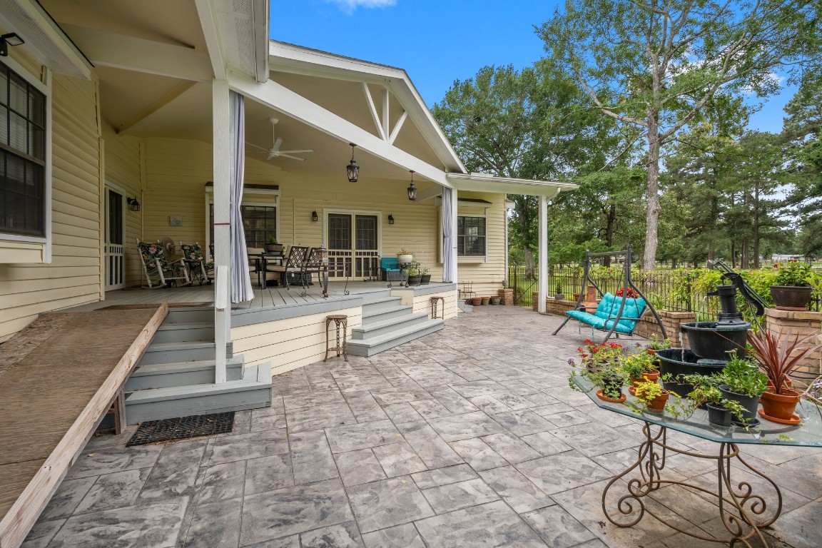 2400 Bowler Road Magnolia, TX 77355 - Photo 10 of 48 a view of a patio with table and chairs potted plants with wooden floor and fence