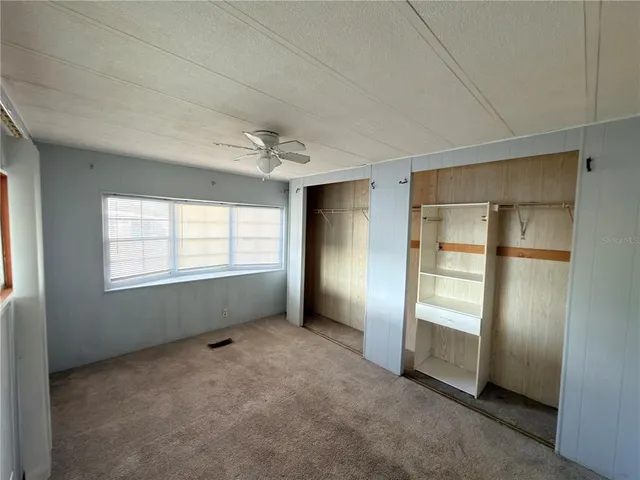 an empty room with windows and closet