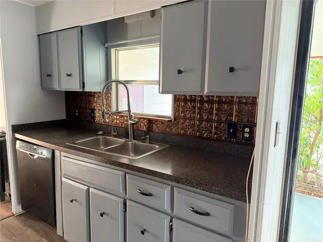 a sink with white cabinets and a granite counter top