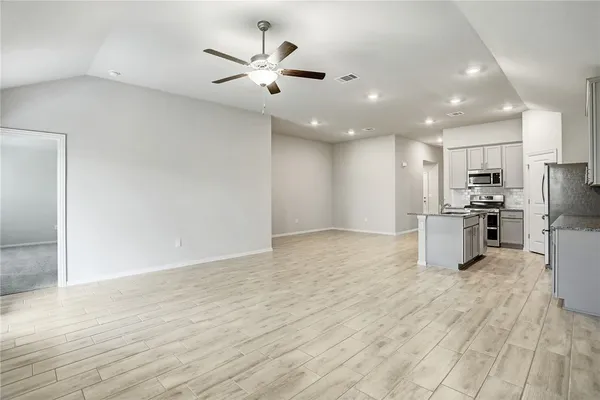 a kitchen with stainless steel appliances kitchen island granite countertop a refrigerator oven a sink and dishwasher