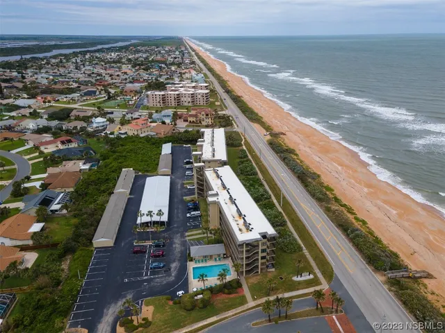 a view of an ocean with a floor to ceiling window and an outdoor seating