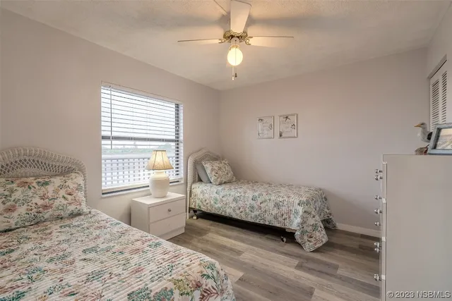 a bedroom with a bed a chandelier and a window