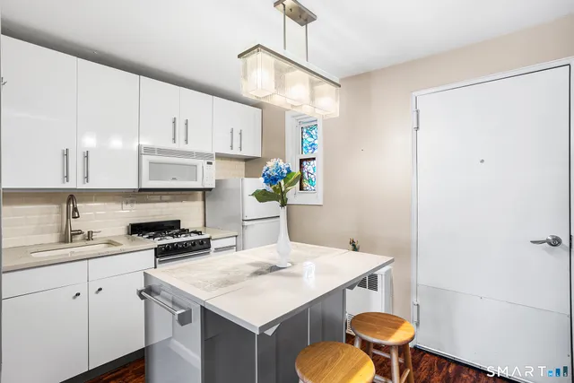 a kitchen with a sink a refrigerator and cabinets