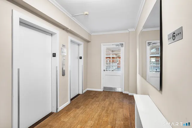 a view of a hallway with wooden floor and closet