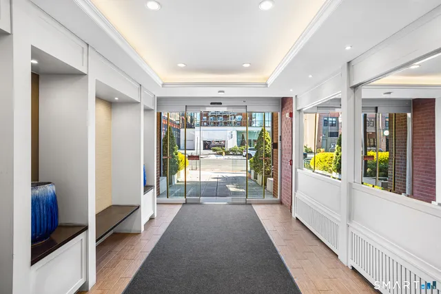 a view of a hallway with large mirror and furniture