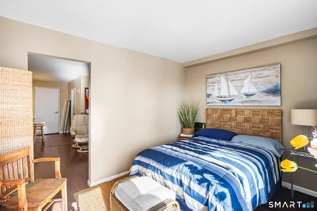 a bedroom with a bed and wooden floor