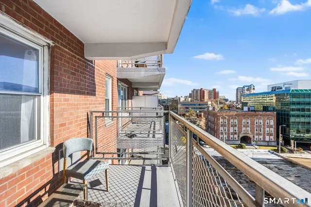 a view of a balcony with wooden chairs