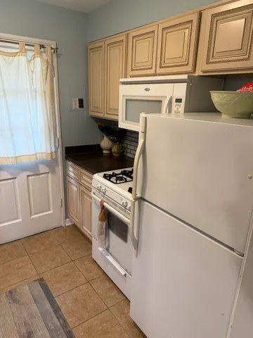 a kitchen with granite countertop a sink a stove and cabinets
