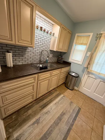 a kitchen with granite countertop a sink stainless steel appliances wooden floor and a counter top space
