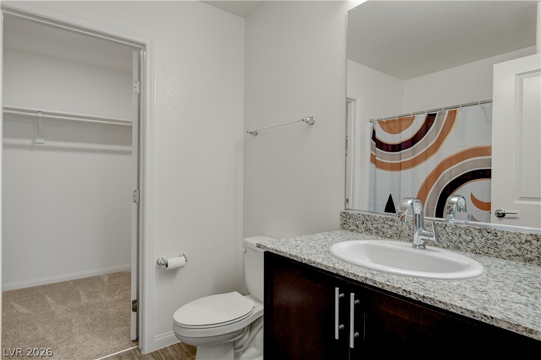6924 Spicy Merlot Street North Las Vegas, NV 89086 - Photo 32 of 83 Granite counters and a dark wood vanity create a clean, contemporary bathroom space.