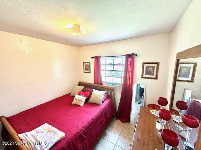 941 Croton Road Melbourne, FL 32935 - Photo 16 of 26 a bedroom with a bed and a large window