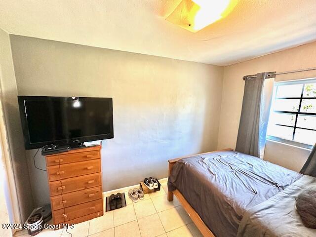 941 Croton Road Melbourne, FL 32935 - Photo 19 of 26 a bedroom with a bed and a flat screen tv