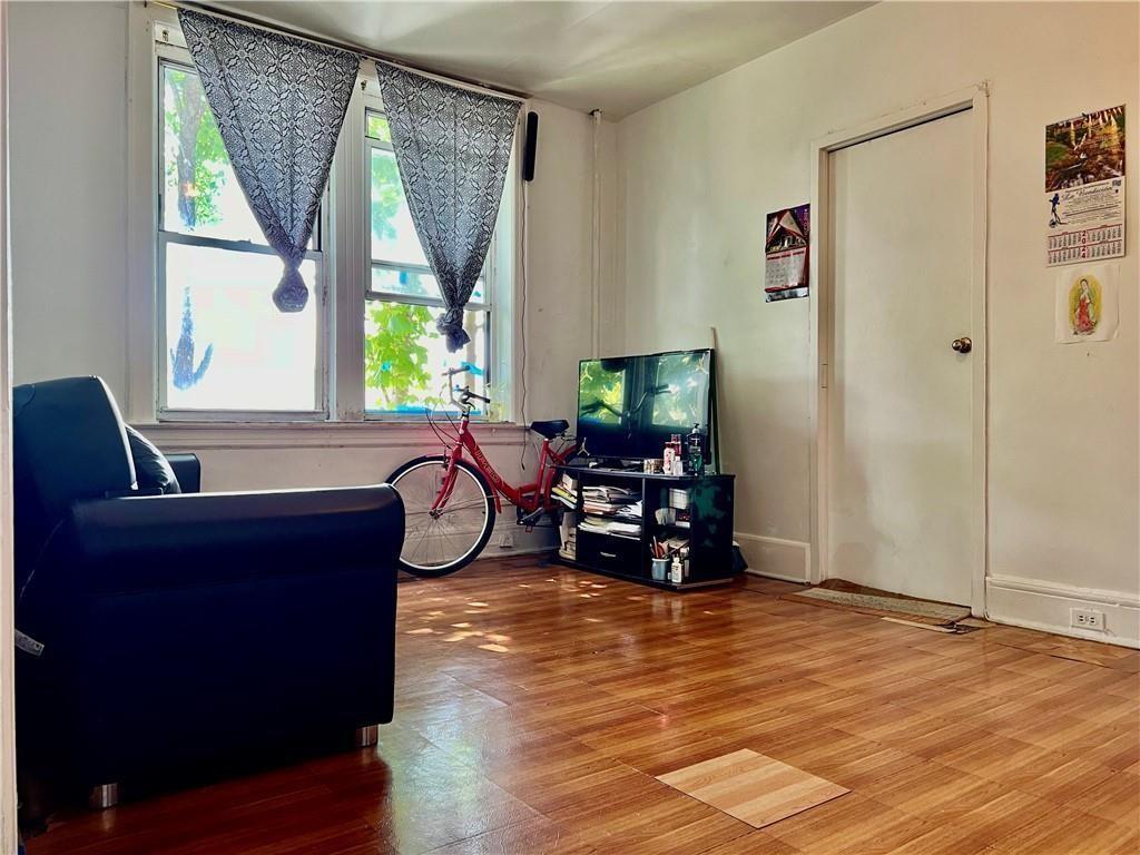 1564 Bay Ridge Avenue Brooklyn, NY 11219 - Photo 2 of 9 a living room with furniture and a flat screen tv with wooden floor