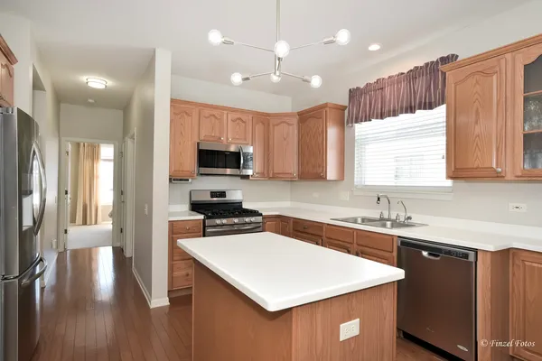 a kitchen with a sink a center island cabinets and a window