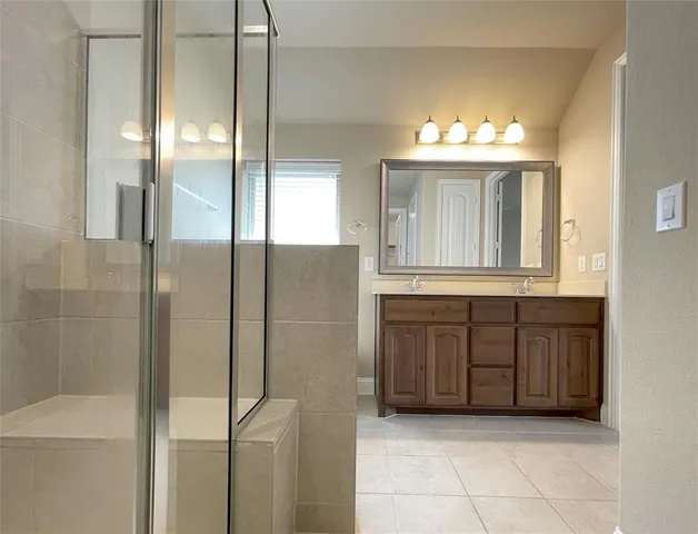 an empty room with wooden floor chandelier fan and windows