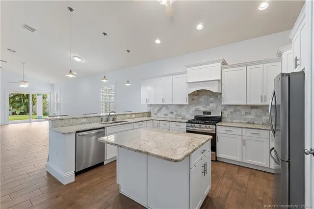a kitchen with a sink a refrigerator and a stove top oven