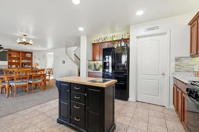 a view of a dining room and livingroom with furniture a chandelier fan a wooden floor and chandelier