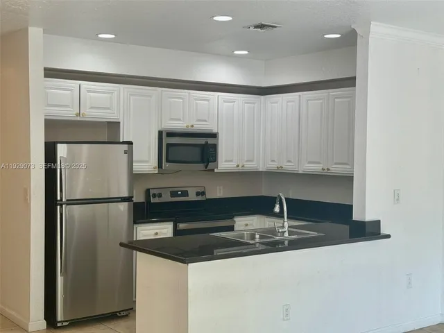 a kitchen with kitchen island a sink stainless steel appliances and cabinets