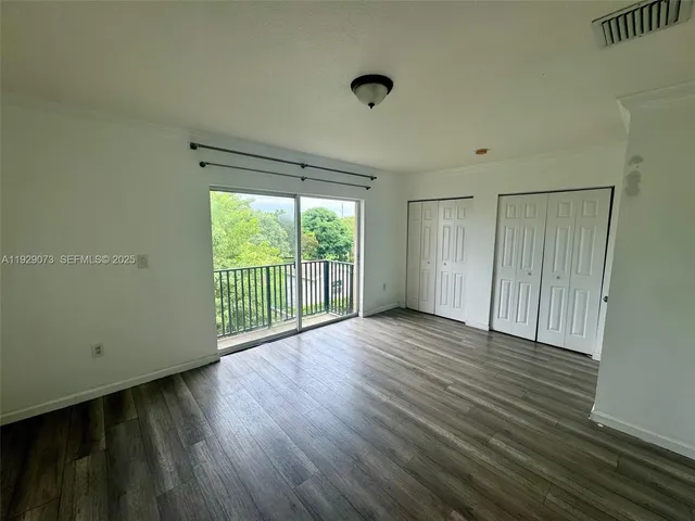 a view of a room with wooden floor and windows
