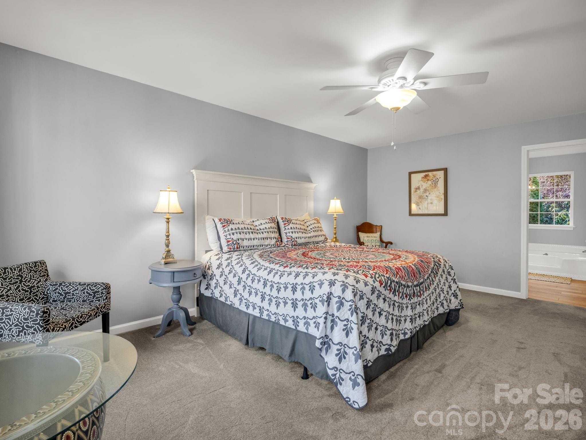 108 Nuthatch Trace Brevard, NC 28712 - Photo 29 of 46 a spacious bedroom with a bed and a chandelier