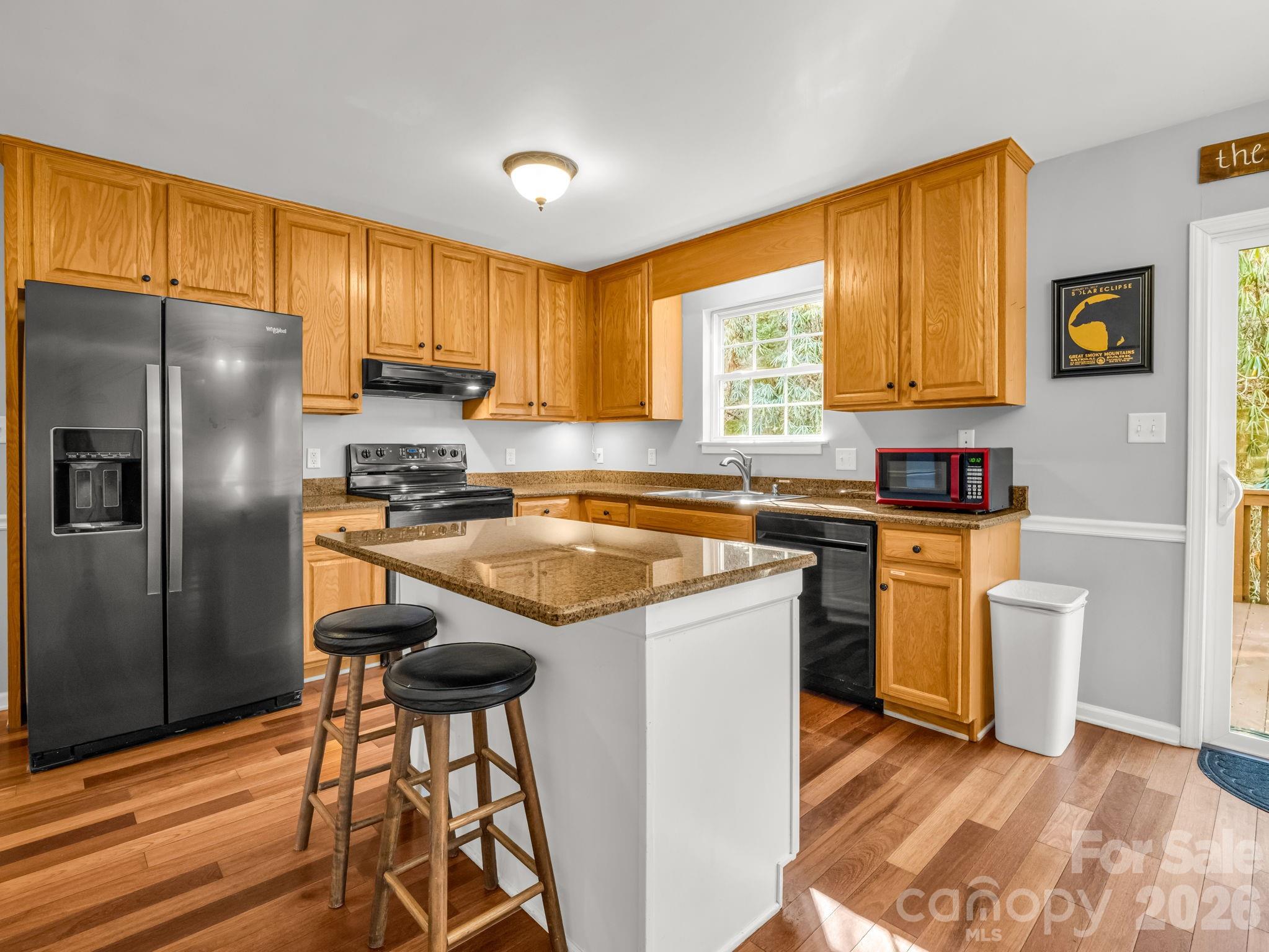 108 Nuthatch Trace Brevard, NC 28712 - Photo 5 of 46 a kitchen with stainless steel appliances granite countertop a sink a stove a refrigerator cabinets and a window