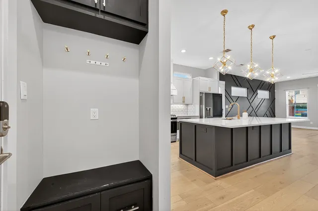 a kitchen with stainless steel appliances a refrigerator and a wooden floor