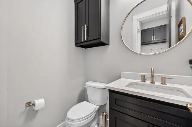 a bathroom with a toilet a sink and mirror