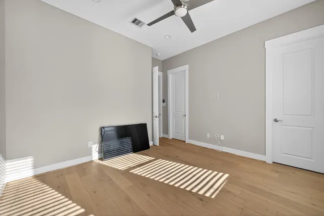 a bedroom with a bed and a ceiling fan