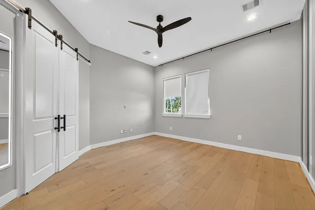 an empty room with windows and fan