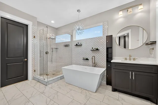 a spacious bathroom with a bathtub shower sink mirror and toilet