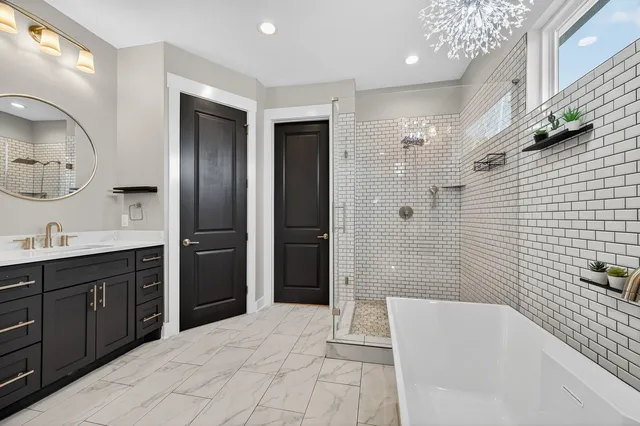 a spacious bathroom with a double vanity sink a large mirror a shower and bathtub