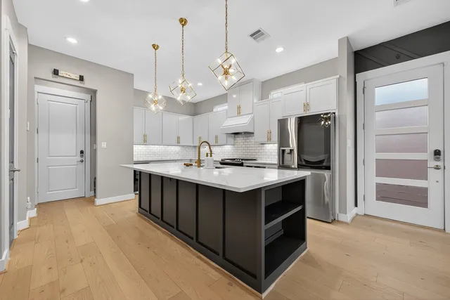 a kitchen with kitchen island a sink stainless steel appliances and cabinets