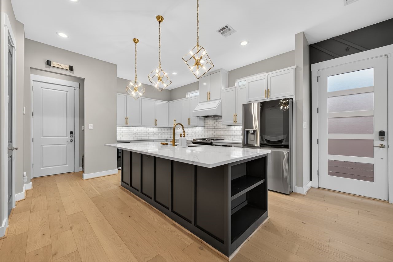 4508 Hardy Street, Unit B Houston, TX 77009 - Photo 5 of 40 a kitchen with kitchen island a sink stainless steel appliances and cabinets