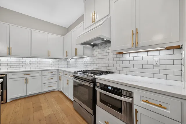 a kitchen with granite countertop white cabinets and appliances