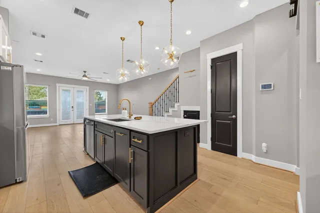 a kitchen with kitchen island a sink a stove a refrigerator and a cabinets
