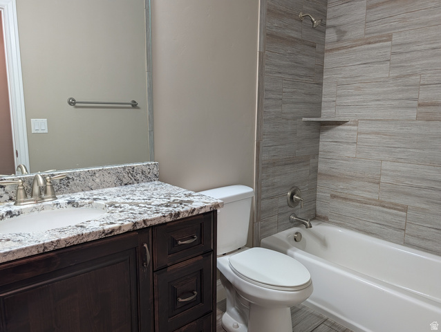 171 South Mustang Road East Grantsville, UT 84029 - Photo 12 of 41 Bathroom featuring a dark wood vanity with a white-and-black speckled countertop, undermount sink, and brushed nickel fixtures
