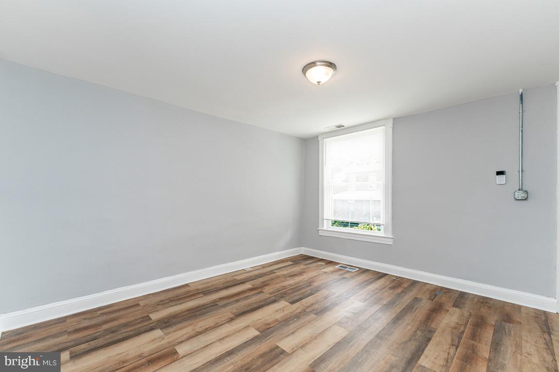 3006 Mathews Street Baltimore, MD 21218 - Photo 7 of 25 an empty room with wooden floor and windows
