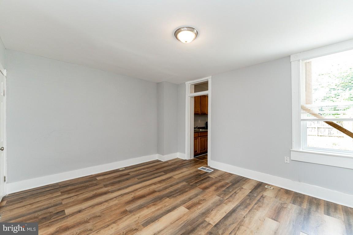 3006 Mathews Street Baltimore, MD 21218 - Photo 10 of 25 an empty room with wooden floor and windows