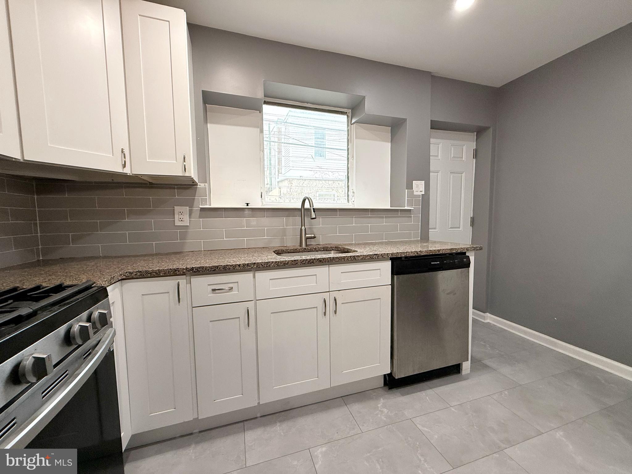1114 Mercy Street Philadelphia, PA 19148 - Photo 11 of 35 a kitchen with granite countertop white cabinets and white appliances