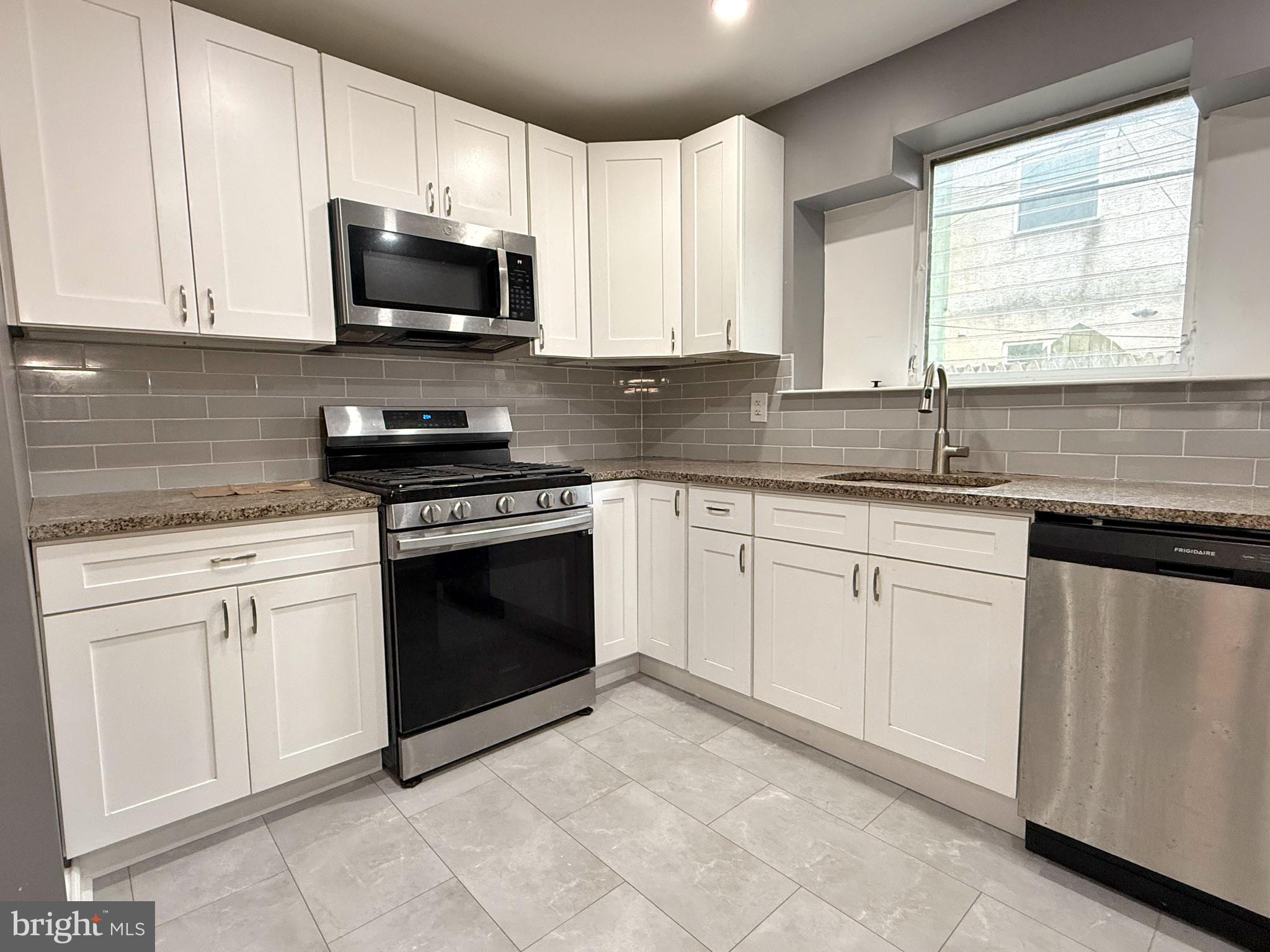1114 Mercy Street Philadelphia, PA 19148 - Photo 12 of 35 a kitchen with white cabinets appliances and a sink