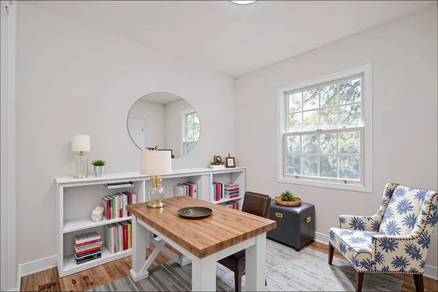 a view of a workspace with furniture and a window